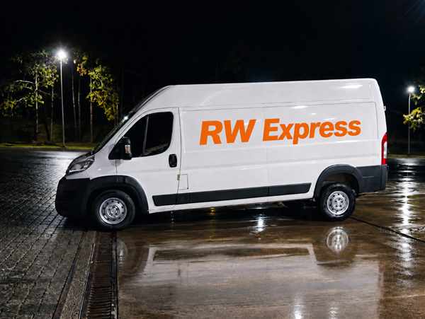 Van branca da RW Express estacionada à noite, pronta para uma operação de transporte